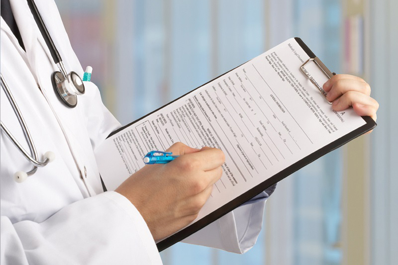 Schmuckbild: eine Ärztin füllt einen Fragebogen auf einem Klemmbrett aus; verlinkt zur Seite 'Lob- und Beschwerdemanagement'