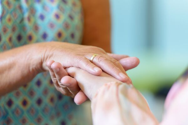 Schmuckbild: zwei Hände halten die Hand einer anderen Person Schmuckbild: zwei Hände halten die Hand einer anderen Person