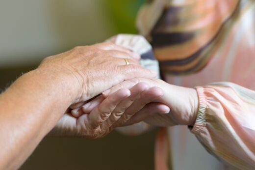 Zwei Hände einer Person umfassen zwei Hände einer anderen Person Zwei Hände einer Person umfassen zwei Hände einer anderen Person