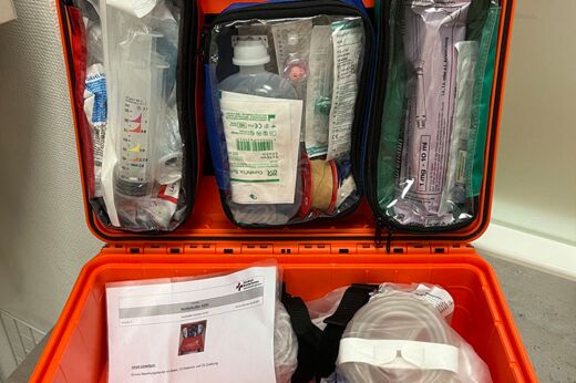 aufgeklappter Notfallkoffer für die Reanimation im Klinikum: roter Koffer mit diversen in Plastik eingepackten medizinischen Kleingeräten und Verbrauchsmaterialien