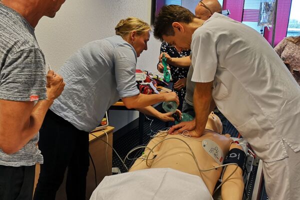 Kursteilnehmende üben die Herz-Lungen-Wiederbelebung an einem Dummy