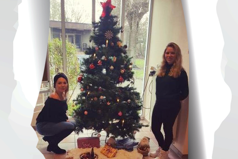 Tag 10: Zwei Auszubildende der Krankenpflegeschule vor dem weihnachtlich geschmückten Tannenbaum am KBR