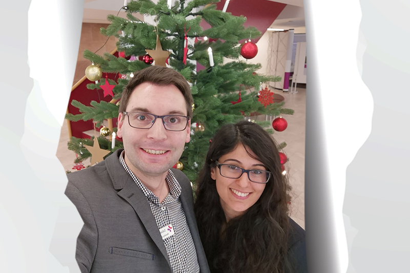 Tag 22: Sebastian Dost und Sara Kheiravi vor dem weihnachtlich geschmückten Tannenbaum am KBR
