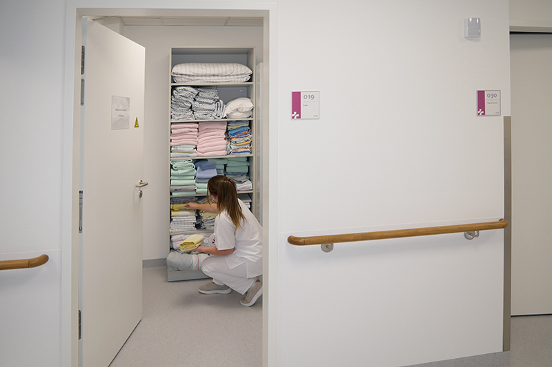 Eine Pflegefachfrau am Textilienregal auf der Nurse-led Unit