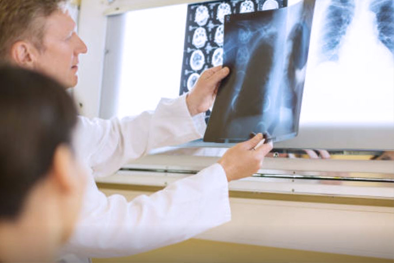 Schmuckbild: ein Arzt erläutert ein Röntgenbild des Brustkorbs; verlinkt zur 'Klinik für Gastroenterologie, Pneumologie, Onkologie, Diabetologie'