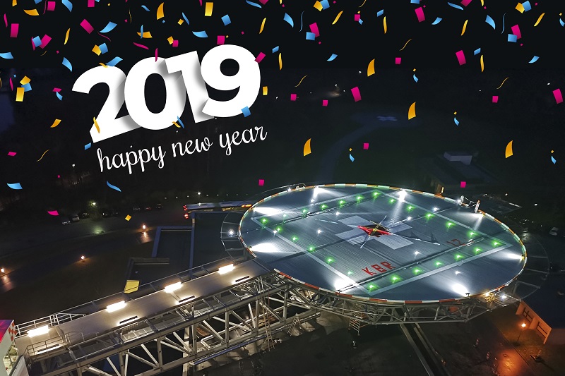 der beleuchtete Hubschrauberlandeplatz mit grafischen Elementen: buntes Konfetti und der Schriftzug 2019 happy new year