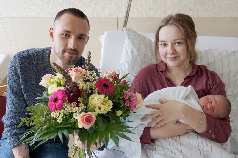 Das 1000. Baby, das 2019 im Klinikum Bremerhaven-Reinkenheide geboren wurde, mit seinen Eltern und einem großen Blumenstrauß