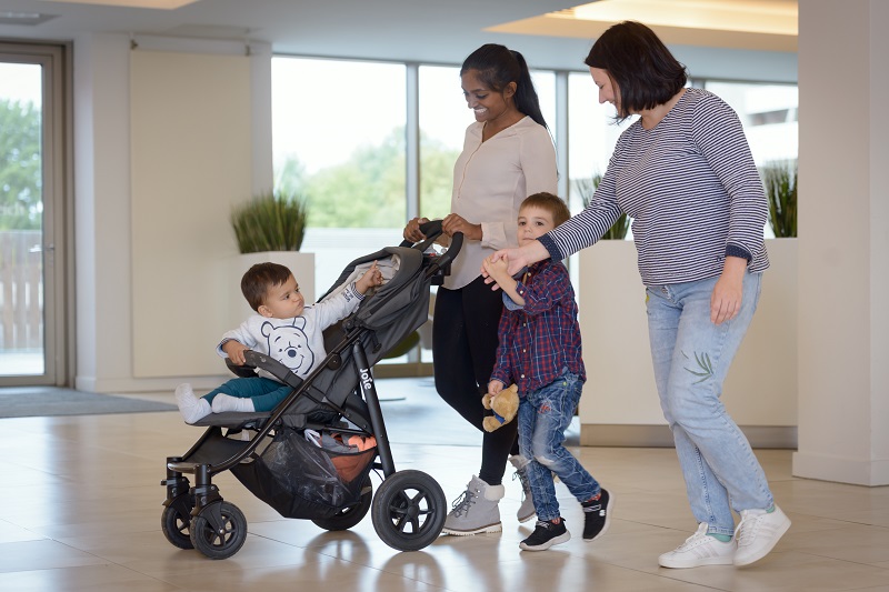 zwei Frauen mit einem Kind an der Hand und einem Kleinkind im Kinderwagen in der Eingangshalle des Klinikums Bremerhaven-Reinkenheide
