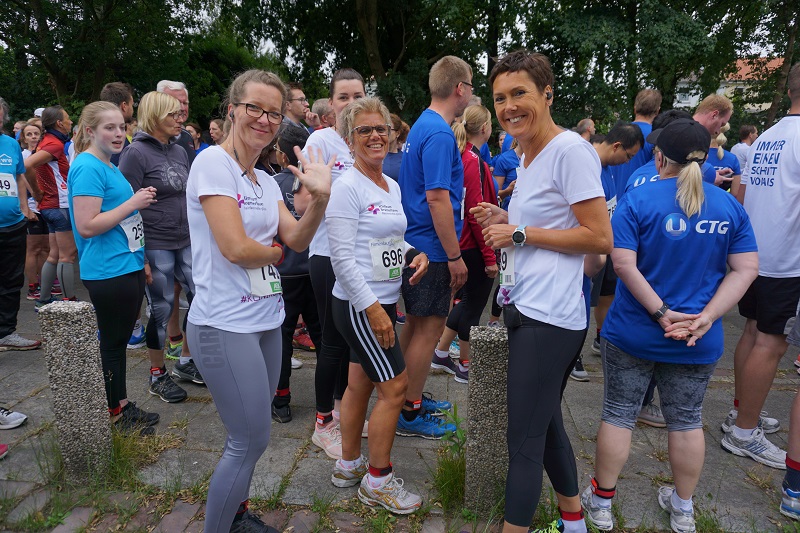 Szenenfoto vom OSC Firmenlauf: Teilnehmende verschiedener Teams warten auf den Start
