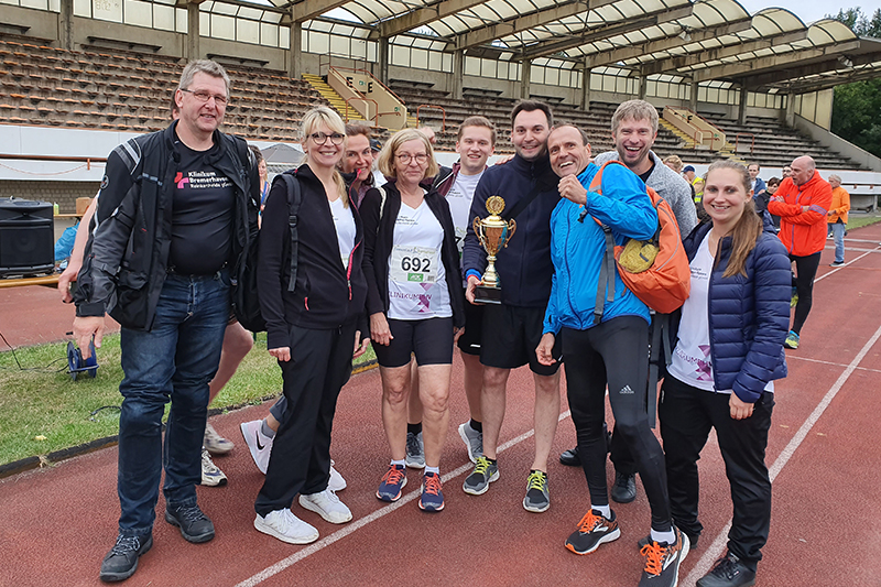 Szenenfoto vom OSC Firmenlauf: einige Teammitglieder mit dem Pokal