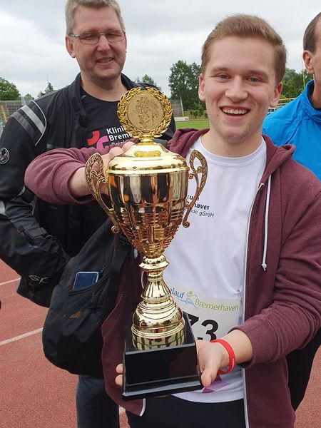 Szenenfoto vom OSC Firmenlauf: zwei Teammitglieder mit dem Pokal
