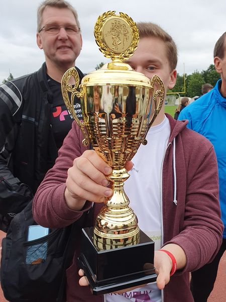 Szenenfoto vom OSC Firmenlauf: zwei Teammitglieder mit dem Pokal