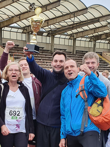 Szenenfoto vom OSC Firmenlauf: einige Teammitglieder mit dem Pokal