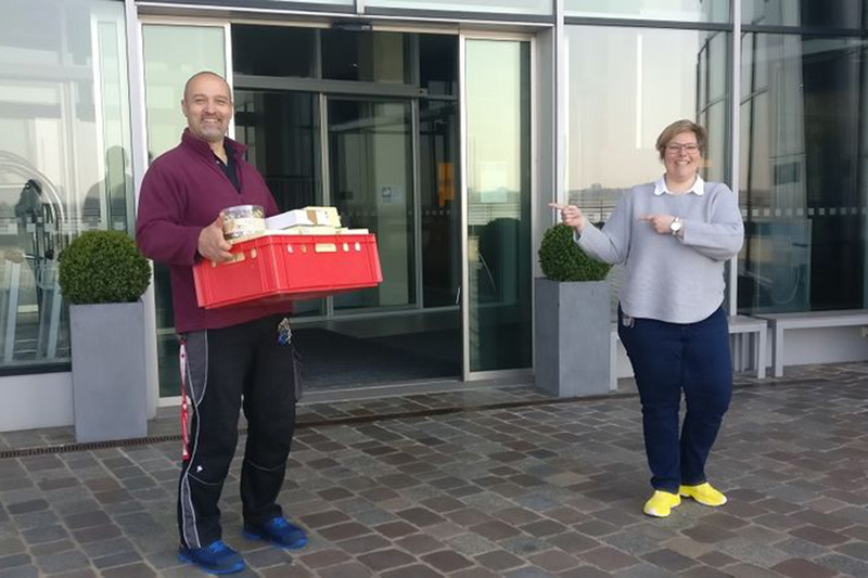 Zwei Mitarbeiter des Atlantic Hotel Bremerhaven mit einer Kiste voller Süßigkeiten als Spende für das Klinikum