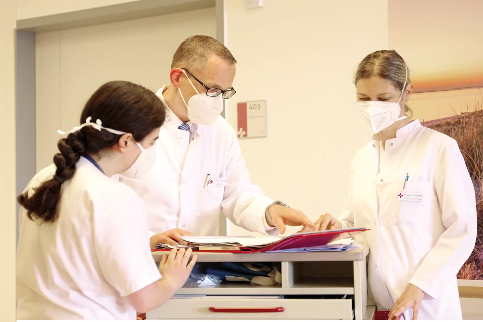 Chefarzt Dr. Sachse und zwei Mitarbeiterinnen des Hautkrebszentrums beim gemeinsamen Studium einer Patientenakte