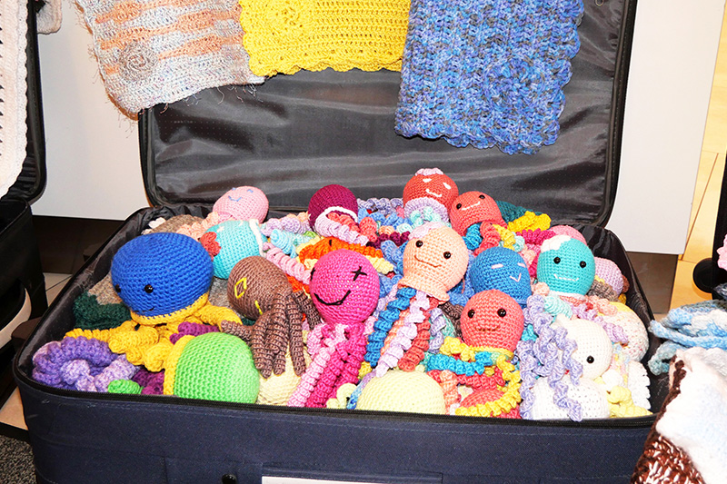 Ein großer Koffer voll mit gehäkelter und gestrickter Kleidung und Kuscheldecken für die Frühchen in der Neonatologie am Klinikum Bremerhaven-Reinkenheide